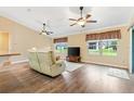 Inviting living room with wood floors, bright windows, neutral paint, and a cozy seating area at 11013 Se 169Th Pl, Summerfield, FL 34491
