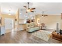 Spacious living room featuring an open layout, neutral tones, hardwood floors, and multiple ceiling fans at 11013 Se 169Th Pl, Summerfield, FL 34491