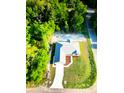 Birds eye view of a single Gathering home with a long driveway and lush green trees at 14 Bay Terrace Pass, Ocklawaha, FL 32179