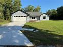 Beautiful single-story home featuring a well-maintained lawn, a long driveway, and an attached two-car garage at 14 Bay Terrace Pass, Ocklawaha, FL 32179