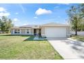 Charming single-story home with a two-car garage, well-maintained lawn, and inviting facade at 159 Water Trak, Ocala, FL 34472