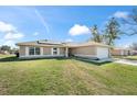 Inviting home with a spacious front yard and a long driveway leading to a two-car garage at 159 Water Trak, Ocala, FL 34472