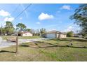 Home with a spacious front yard and a long driveway leading to a two-car garage and guest home at 159 Water Trak, Ocala, FL 34472