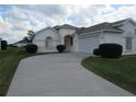 Charming single-story home featuring a well-manicured lawn, mature shrubbery, and a concrete driveway at 2459 Nw 55Th Avenue Rd, Ocala, FL 34482