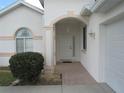 Inviting front porch with tile flooring, a hanging lantern, and decorative columns with a white front door at 2459 Nw 55Th Avenue Rd, Ocala, FL 34482