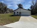 Well-kept single-story home features fresh exterior and a spacious concrete driveway at 31 Juniper Pass Ln, Ocala, FL 34480