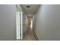 Long hallway with wood-look flooring and neutral walls, leading to other areas of the home at 31 Juniper Pass Ln, Ocala, FL 34480