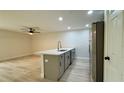 Modern kitchen featuring an island with sink, stainless steel appliances, and wood-look flooring at 31 Juniper Pass Ln, Ocala, FL 34480