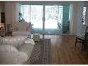 Comfortable living room with hardwood floors, plush seating, and sliding glass doors leading to the lanai at 5181 Sw 164Th Street Rd, Ocala, FL 34473