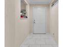 Inviting entryway featuring elegant white marble floors and a classic white front door at 5758 Nw 63Rd Pl, Ocala, FL 34482