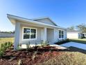 Beautiful single-story home with a charming covered porch, a concrete walkway, and simple landscaping at 6584 Se 108Th Ln, Belleview, FL 34420