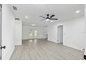 Bright living room featuring sleek, light wood-look flooring and a modern ceiling fan at 7280 Se County Highway 25A, Belleview, FL 34420
