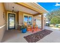 Inviting front porch with comfortable seating, potted plants, and an outdoor rug creating a welcoming entrance at 9841 Sw 95Th Loop, Ocala, FL 34481