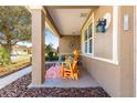 Charming covered front porch with seating area, complemented by stylish decor and a welcoming ambiance at 9841 Sw 95Th Loop, Ocala, FL 34481