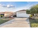 The home features a 2 car garage, driveway, and well maintained landscaping at 10071 Sw 90Th Loop, Ocala, FL 34481