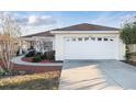 A view of the home and driveway, showing the two-car garage and well-kept lawn at 10071 Sw 90Th Loop, Ocala, FL 34481