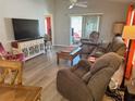 Bright living room featuring stylish furniture, a large TV, and access to the outdoors at 1118 Pelion Pl, The Villages, FL 32162