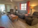 Inviting living room featuring hardwood floors, comfortable seating, and lots of natural light at 1118 Pelion Pl, The Villages, FL 32162