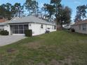 A view of the home's exterior showing the lawn, screened porch, and the side of the home at 11665 Sw 72Nd Cir, Ocala, FL 34476