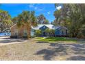 Beautiful home featuring stone accents, a metal roof, and mature palm trees at 12336 E Highway 25, Ocklawaha, FL 32179