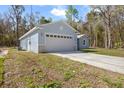 A charming home with a two-car garage and light blue exterior paint, complemented by lush landscaping at 12876 Se 42Nd Ct, Belleview, FL 34420