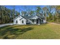 Well-maintained single-Gathering home on a grassy lawn, surrounded by trees and nature at 13751 Sw 49Th Pl, Ocala, FL 34481