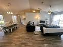 Open-concept living room with wood floors and ample natural light at 15055 Se 93Rd Ct, Summerfield, FL 34491