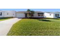 Charming single-story home with a well-manicured lawn, palm trees and a cozy entryway at 2013 Cardona Way, The Villages, FL 32159