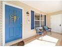 Inviting front porch with seating, a bright blue door, and charming decor at 3321 Woodridge Dr, The Villages, FL 32162