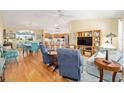 Open-concept living room flows into the dining area and kitchen with wood floors and plenty of natural light at 3321 Woodridge Dr, The Villages, FL 32162
