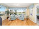 Cozy sunroom with views of the lake, bright decor and hardwood floors at 3321 Woodridge Dr, The Villages, FL 32162