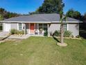 Charming single-story home with well-manicured lawn and inviting front porch seating area at 622 Nw 56Th Ave, Ocala, FL 34482