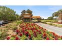 Community entrance featuring a guard house, colorful flower beds, and well-maintained landscaping at 8350 Sw 93Rd Ln # C, Ocala, FL 34481