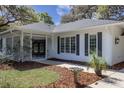 Inviting front porch with decorative details, a charming fountain, and lush landscaping creating a welcoming entrance to this home at 8380 Se 7Th Avenue Rd, Ocala, FL 34480