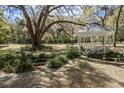 Beautiful white gazebo nestled in a tranquil garden setting with lush greenery and mature trees at 8380 Se 7Th Avenue Rd, Ocala, FL 34480