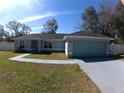 Beautiful single-story home with a well-maintained lawn and a blue two-car garage at 8890 Sw 33Rd Ct, Ocala, FL 34476