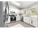 Well-lit kitchen features modern stainless appliances, white cabinets and a large window at 9365 Sw 89Th Ter # F, Ocala, FL 34481