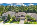 Inviting two-story home boasts a well-manicured lawn, elegant brick driveway, and mature trees at 1073 Vinsetta Cir, Winter Garden, FL 34787