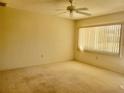 Spacious bedroom with ceiling fan, carpet flooring, and natural light from window at 11255 Sw 76Th Ter, Ocala, FL 34476
