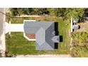 Aerial view of a gray roof single-Gathering home with a two car garage, green lawn, and landscaping at 114 Bay Dr, Ocklawaha, FL 32179