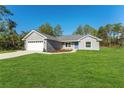 Charming gray single-Gathering home featuring a blue front door, a two-car garage, and a well-maintained lawn at 114 Bay Dr, Ocklawaha, FL 32179
