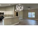 Bright kitchen with a breakfast bar, stainless appliances, and granite countertops seamlessly connected to the living area at 114 Bay Dr, Ocklawaha, FL 32179