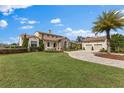 Elegant home featuring lush landscaping, a brick driveway, and a two-car garage at 12424 Sw 140Th Loop, Dunnellon, FL 34432