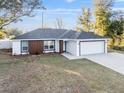 Well-maintained one-story residence with a contemporary color scheme, a two-car garage, and a lush lawn at 13384 Sw 105 Pl, Dunnellon, FL 34432