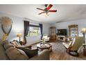 Cozy living room with hardwood floors, large windows, and comfortable seating at 13751 Se 88Th Ct, Summerfield, FL 34491