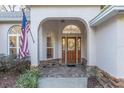 Inviting entryway featuring a wooden door, stone accents, and decorative brickwork at 13920 Ne 38Th Ave, Anthony, FL 32617