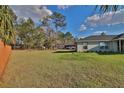Expansive backyard featuring a lush lawn, mature trees, and partial fencing providing ample space for outdoor activities at 14 Hemlock Loop Court, Ocala, FL 34472