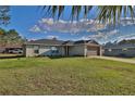 Charming one-story home with a well-maintained lawn, landscaping, and a two-car garage at 14 Hemlock Loop Court, Ocala, FL 34472