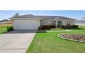 Attractive single-story home boasts a two-car garage, tidy landscaping, and a pristine lawn at 14 Juniper Drive Crse, Ocala, FL 34480