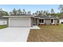 Charming single-story home featuring a two-car garage, well-maintained lawn, and an inviting entrance at 14409 Sw 30Th Street Rd, Ocala, FL 34481